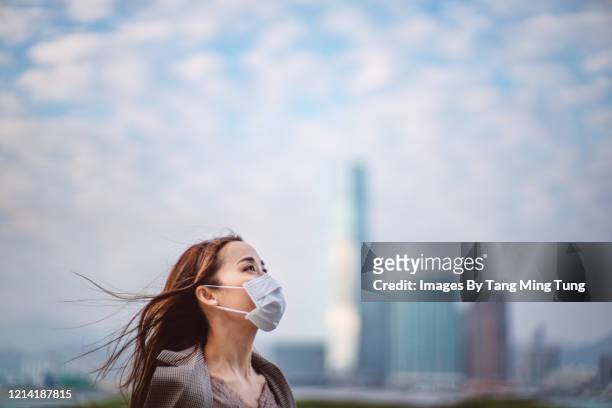 portrait of young asian lady with face mask to protect and prevent from the spread of viruses in the city - luftverschmutzung stock-fotos und bilder