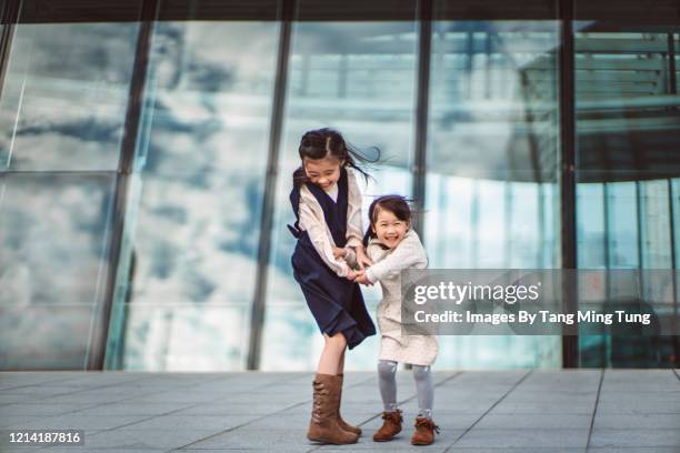little sibling playing joyfully in business district - fashionable family stock pictures, royalty-free photos & images
