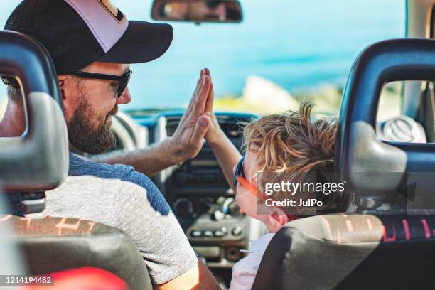 roadtrip. vader en zoon die samen met auto reizen - auto sommer stockfoto's en -beelden