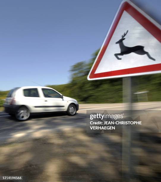 Une voiture passe le 19 août 2009 à Atton devant un panneau prévenant du danger représenté par le passage d'animaux sauvages sur la route. 42.471...