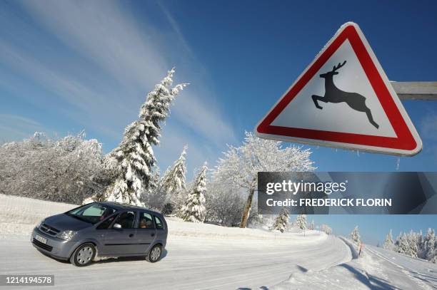 Une voiture passe devant un panneau prévenant du passage possible de gibier sur la route le 18 février 2008 à Belmont. AFP PHOTO/ FREDERICK FLORIN