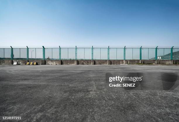 road next to a fence - prison fence stock pictures, royalty-free photos & images