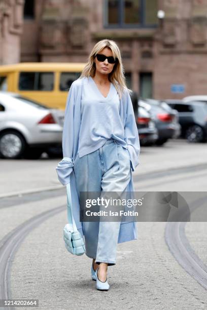 Influencer Gitta Banko, wearing a jeans by Magda Butrym, a pastel blue pullover and a pastel blue cardigan by t7berlin, a topaz colored padded...