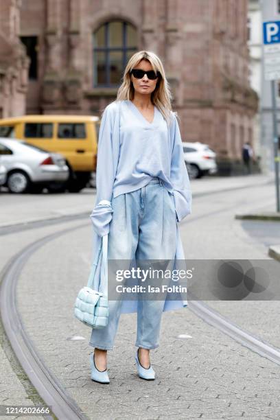 Influencer Gitta Banko, wearing a jeans by Magda Butrym, a pastel blue pullover and a pastel blue cardigan by t7berlin, a topaz colored padded...