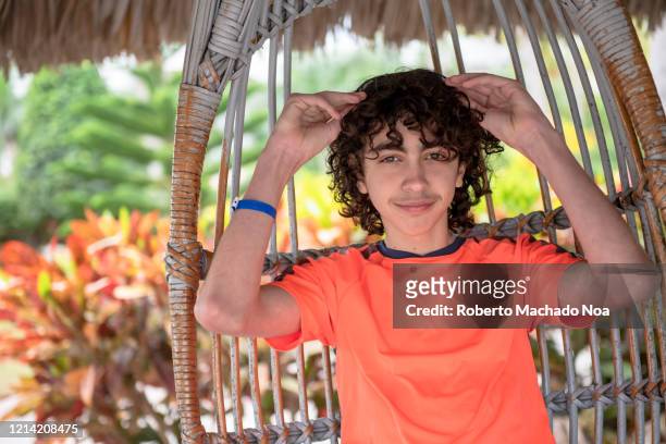 male teenager enjoying a resort garden, cuba - roberto ricciuti foto e immagini stock