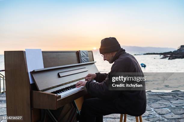 playing a piano in front of the ocean - pianist front stock pictures, royalty-free photos & images