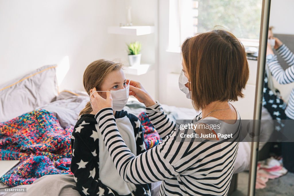 Mother putting mask on daughter