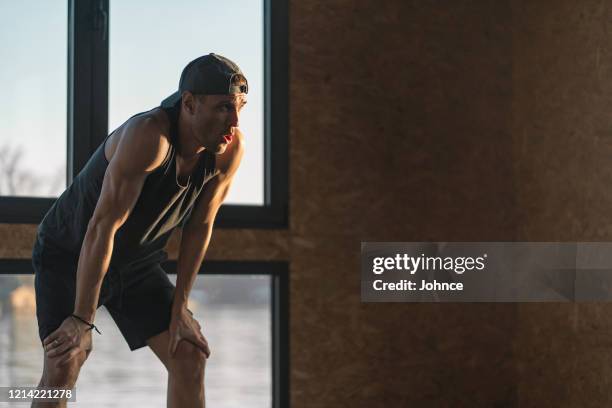 young man takes a rest after training - hand on knee stock pictures, royalty-free photos & images