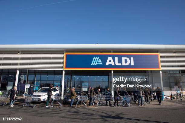 Shoppers queue outside an Aldi supermarket on March 23, 2020 in London, England. Coronavirus pandemic has spread to at least 182 countries, claiming...