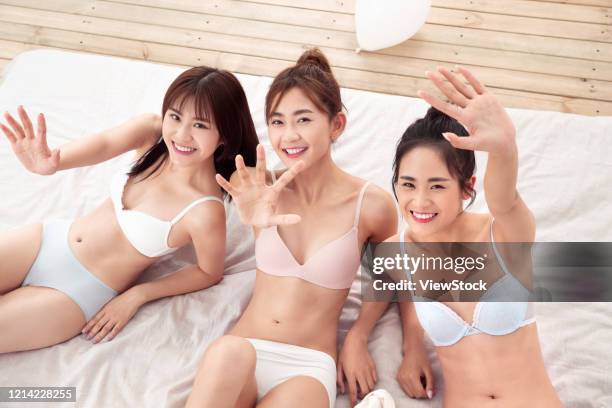 girlfriends sitting on the bed to play - seize the day bed private view stock pictures, royalty-free photos & images