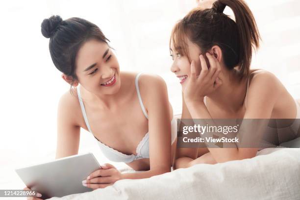 girlfriends lying on the bed to see tablets - seize the day bed private view stock pictures, royalty-free photos & images