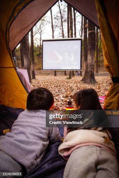 children on outdoor camping tents, see a movie - development camp stock pictures, royalty-free photos & images