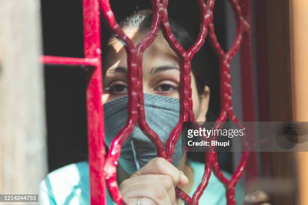 the sad girl is protecting herself and wearing a mask against the corona virus - lockdown stock pictures, royalty-free photos & images