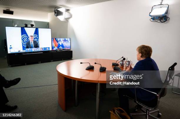 In this handout photo provided by the German Government Press Office , German Chancellor Angela Merkel looks on as Guy Ryder, Director General of the...