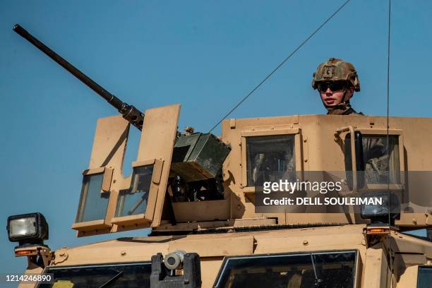Soldier mans the turret of an MRAP vehicle while on patrol along the M4 highway by the town of Tal Tamr and its countryside in Syria's northeastern...