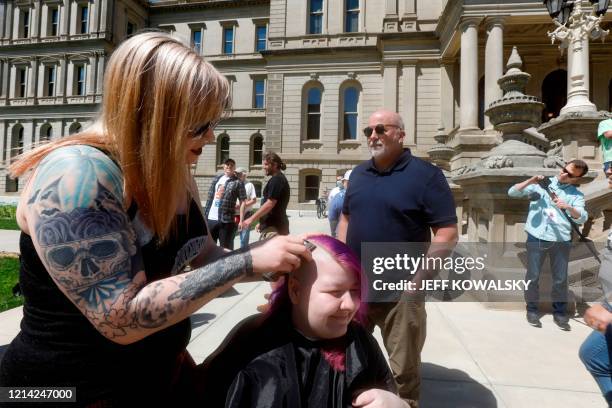 Casie Stoops gets her hair cut at the Michigan Conservative Coalition organized "Operation Haircut" outside the Michigan State Capitol in Lansing,...