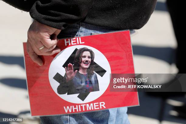 People demonstrate during the Michigan Conservative Coalition organized "Operation Haircut" outside the Michigan State Capitol in Lansing, Michigan...