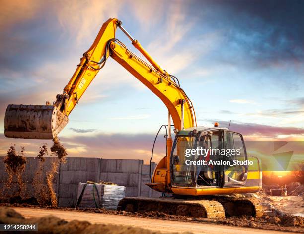 excavator at a construction site against the setting sun - bridge built structure stock pictures, royalty-free photos & images