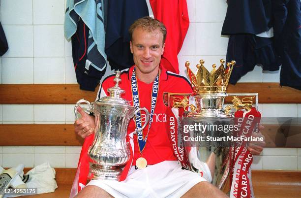 Dennis Bergkamp of Arsenal with the FA Cup Trophy and the Premier League Trophy after the Premier League match between Arsenal and Everton on May 11,...