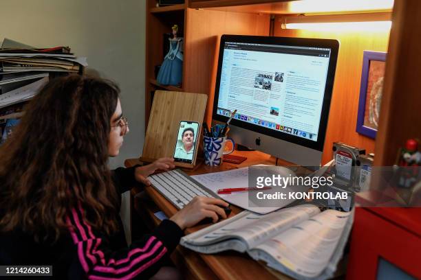 Girl is studying connected online and streaming with her teacher and her other classmates to recover the school days lost in this period of closed...