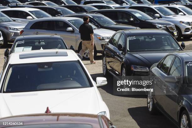 Car dealer walks past cars for sale at a used car dealership in Jersey City, New Jersey, U.S, on Wednesday, May 20, 2020. Governor Phil Murphy has...