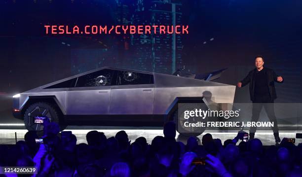 Tesla co-founder and CEO Elon Musk on stage with the newly unveiled all-electric battery-powered Tesla Cybertruck with broken glass on windows...