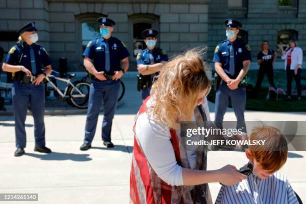 Barbers cut hair during the Michigan Conservative Coalition organized "Operation Haircut" outside the Michigan State Capitol in Lansing, Michigan on...