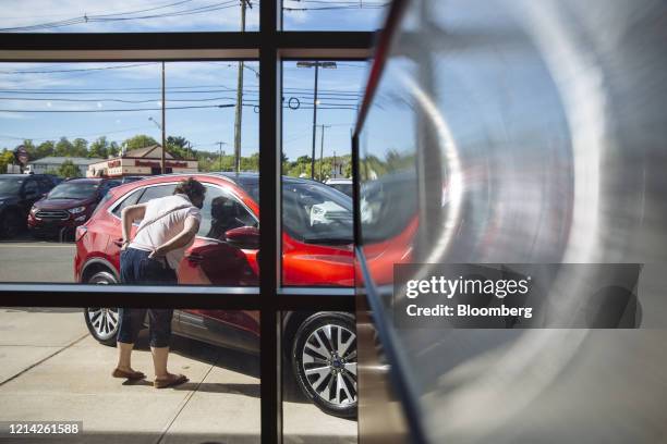 Person looks at a vehicle displayed for sale at a Ford Motor Co. And Kia Motors Corp. Car dealership in Clifton, New Jersey, U.S, on Wednesday, May...