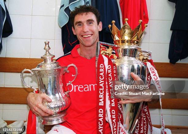 Martin Keown of Arsenal with the FA Cup Trophy and the Premier League Trophy after the Premier League match between Arsenal and Everton on May 11,...