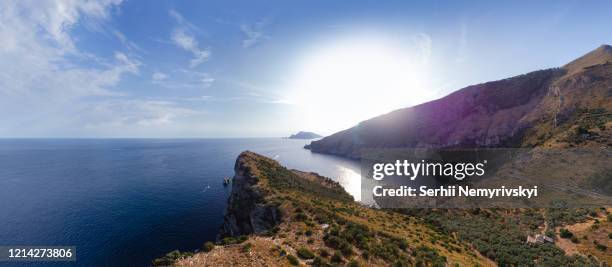 aerial wide view panorama of ieranto bay in demi-island sorrento, mountains, rocky shores and sea. capri is far on the horizon. water transport movement. recreation and tourism, naples, italy - bay of water fotografías e imágenes de stock