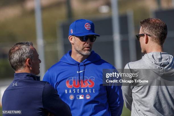 From left, Chicago Cubs executive vice president Jed Hoyer, manager David Ross and team president Theo Epstein talk near a practice field during...