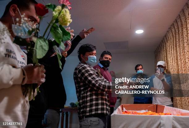 Pawan KC , the cousin of the deceased Ashish KC, performs funeral rites, while others, all wearing facemasks, live stream the event at the Maryland...