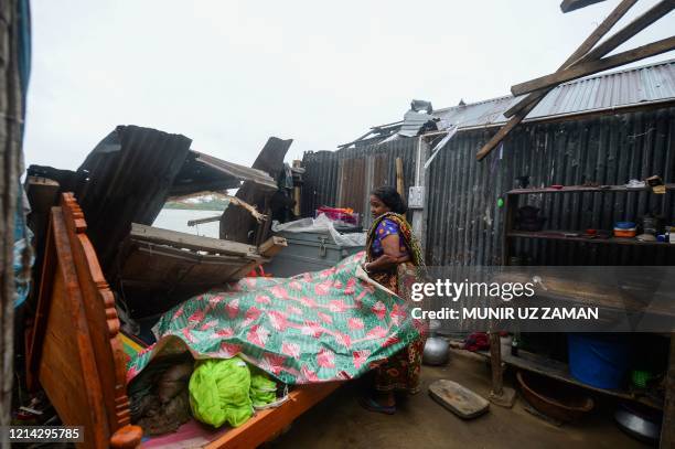 Woman salvages items from her house damaged by cyclone Amphan in Satkhira on May 21, 2020. - The strongest cyclone in decades slammed into Bangladesh...