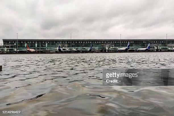 Aircraft are parked at a terminal near the flooded tarmac at Netaji Subhas Chandra Bose International Airport after the landfall of cyclone Amphan in...