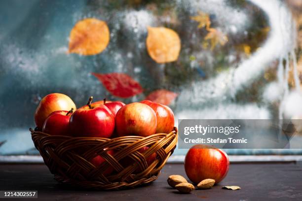 ripe red apples in wicker basket on a kitchen table - brown apple stock pictures, royalty-free photos & images