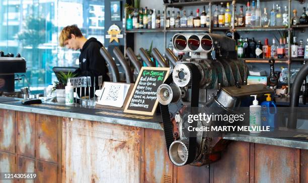 Bartender works at the bar on the first day of re-opening after establishments were shut for two months due to the COVID-19 coronavirus outbreak in...