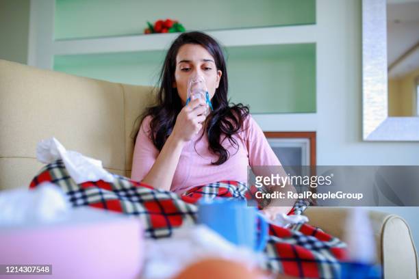 young woman using an asthma inhaler- coronavirus - problems stock pictures, royalty-free photos & images