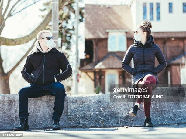 covid-19, young couple meeting outside - social distancing stock pictures, royalty-free photos & images
