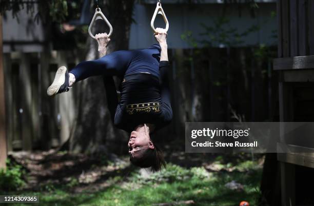 Natasha Danchenko, an aerialist specializing in silks maintains her strength by training on the backyard swing set of her home as the Toronto arts...