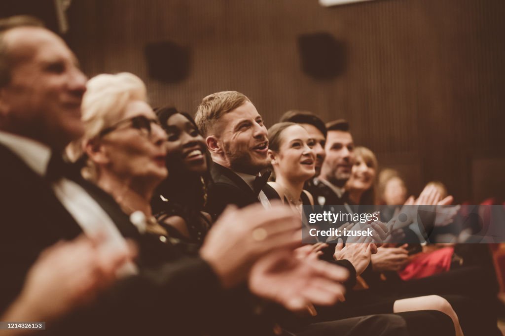 Público emocionado aplaudiendo en el teatro