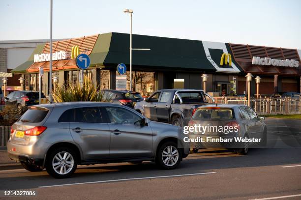 Long queues outside a McDonald's restaurant and drive thru prior to closure on March 23, 2020 in Weymouth, United Kingdom. Coronavirus pandemic has...