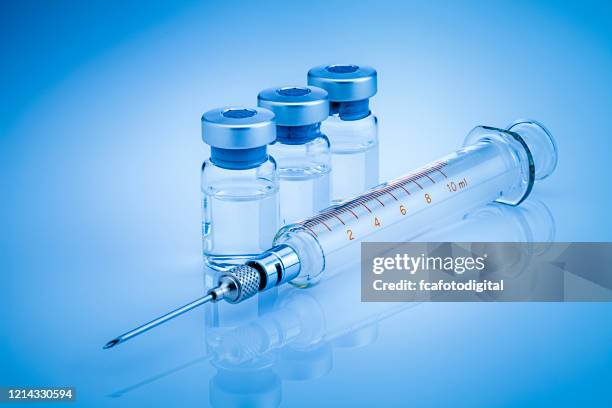 coronavirusvaccin: spruta och injektionsflaska på blå bakgrund - medicinflaska bildbanksfoton och bilder