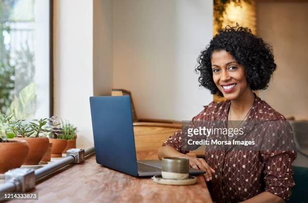 mulher usando laptop enquanto estava sentada em café - 35 39 anos - fotografias e filmes do acervo