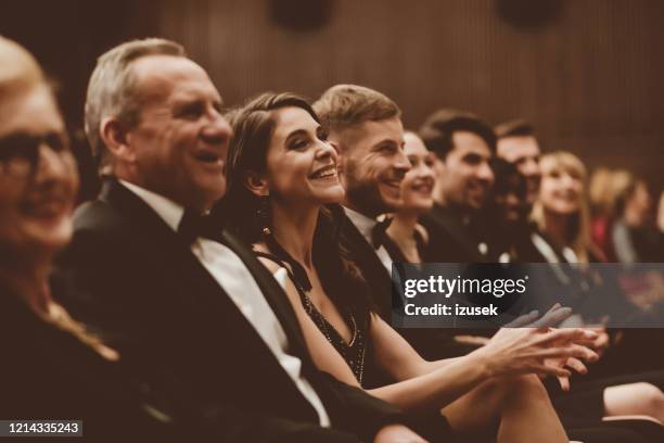 pubblico sorridente seduto a teatro - spettatore opera foto e immagini stock