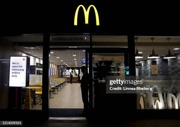 McDonalds staff member prepares to close the Wood Green branch, as a sign is displayed to inform customers of a takeaway only option on March 23,...