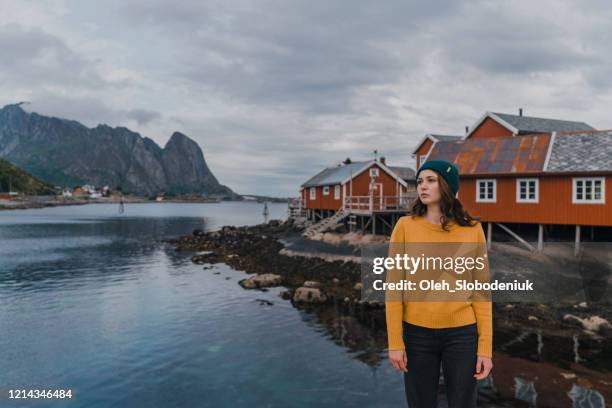 kvinna i byn reine på lofoten - röd hatt bildbanksfoton och bilder