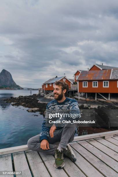 man in reine village in lofoten islands - traditionally norwegian stock-fotos und bilder