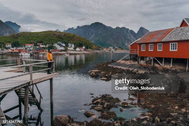 woman in reine village in lofoten islands - red hat stock pictures, royalty-free photos & images