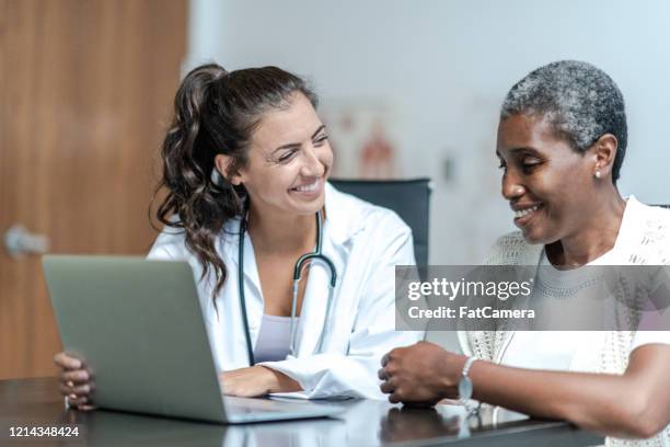 高齢患者のストック写真を持つ若い女性医師 - spanish and portuguese ethnicity ストックフォトと画像