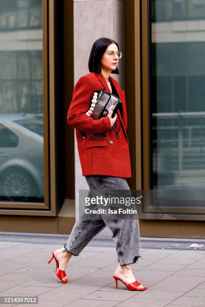 Influencer Maria Barteczko, wearing a red checked oversized blazer by Custommade, a knit top by Pixie Market, a grey slouchy jeans by Zara, red mules...